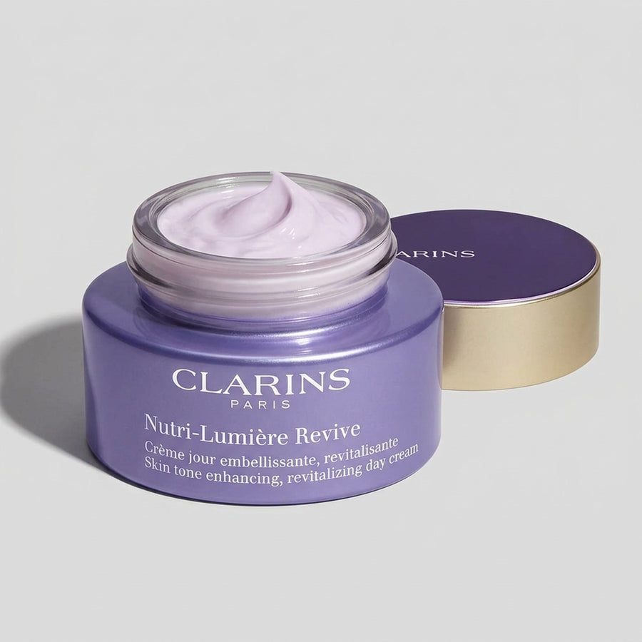 Tarro abierto de Clarins Nutri-Lumière Revive con su crema lila