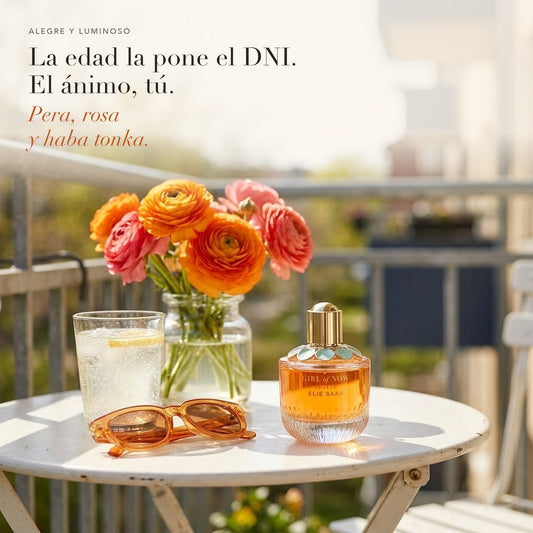 Elie Saab Girl of Now Lovely en una mesa de balcón con ranúnculos y gafas de sol